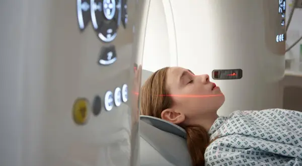 Mädchen in CT-Scanner, rote Laserlinien zur Positionierung für die Untersuchung, um einen ct tumor erkennen zu können.