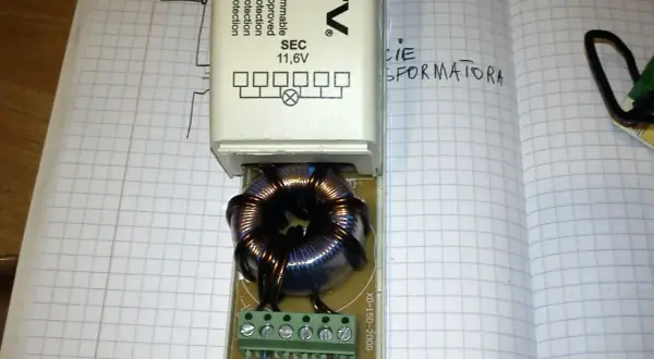 Schemat podłączenia transformatora elektronicznego GTV TE-150. Widać uzwojenie i zaciski do podłączenia przewodów.