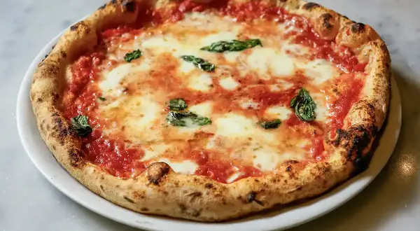 Eine authentische Pizza Margherita, wie sie in der Pizzeria Brandi in Neapel serviert wird, mit frischem Basilikum und geschmolzenem Mozzarella.