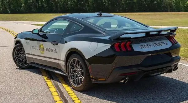 Czarny Ford Mustang w barwach policji "State Trooper" z napisem na boku i tyle.