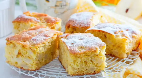 Pyszny przepis na ciasto z jabłkami, posypane cukrem pudrem. Idealne na jesienne popołudnie.