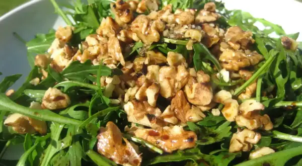 Ensalada de rucula fresca con nueces tostadas y un glaseado balsámico. Un plato ligero y sabroso.