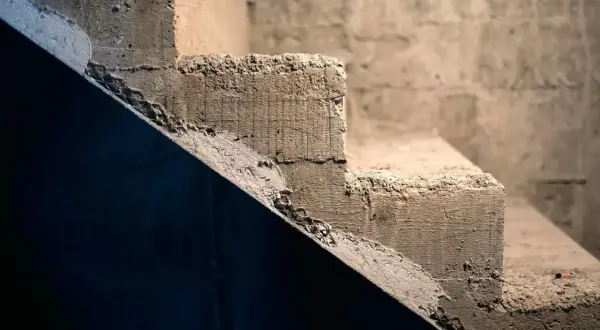 Surowe, betonowe schody czekają na wykończenie. Pomysły, jak tanio wykończyć schody betonowe, mogą obejmować malowanie lub położenie wykładziny.
