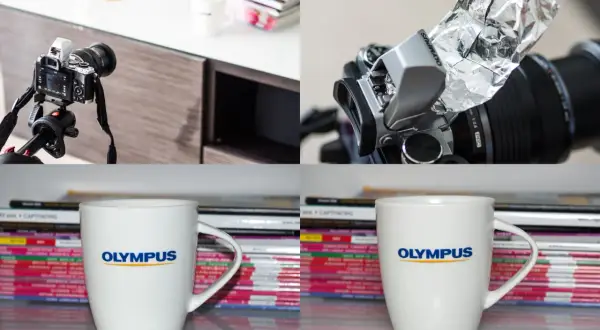 Aparat Olympus z lampą błyskową i dyfuzorem z folii aluminiowej, kubek Olympus na tle stosu magazynów.