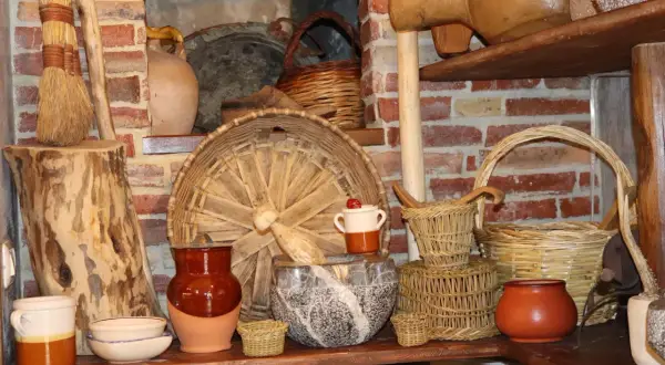 Vasi in terracotta, cesti intrecciati e scope di paglia evocano antiche attività artigianali.