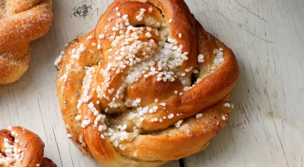 Gyllene kardemummabullar med pärlsocker, redo att bakas enligt ett enkelt kardemummabullar recept.