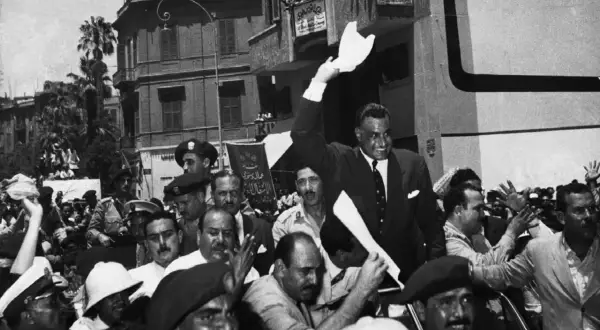 Gamal Abdel Nasser, drugi prezydent Egiptu, pozdrawia tłum z otwartego samochodu.