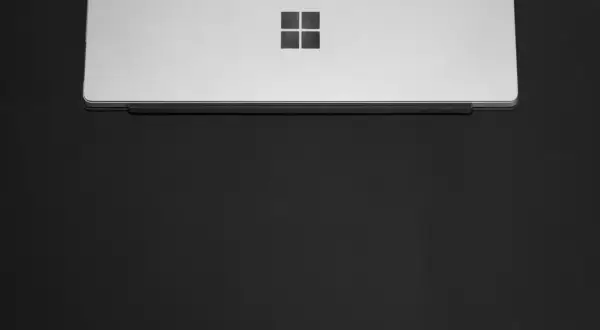 Srebrny laptop z logo Windows. Dowiedz się, jak ustawić hasło na komputer, by chronić swoje dane.