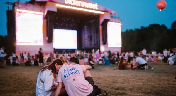 Para na trawie przed sceną festiwalu Bittersweet 2026. W tle tłum i wielkie ekrany.