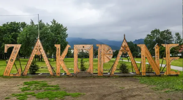 Drewniany napis "ZAKOPANE" na tle gór. Idealne miejsce na rozpoczęcie poszukiwań zakopane atrakcje dla dorosłych.