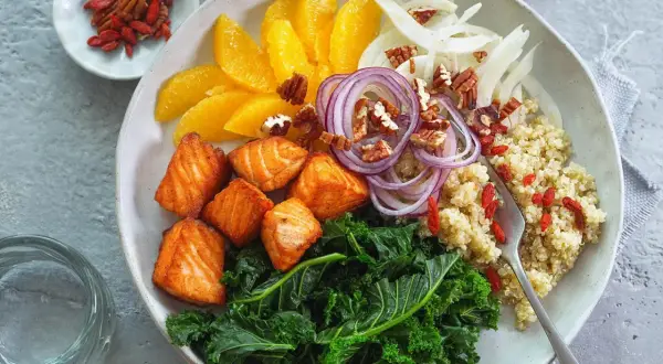 Gesunde Bowl-Rezepte: Lachs, Grünkohl, Quinoa, Orange, Fenchel, rote Zwiebeln, Pekannüsse und Goji-Beeren.