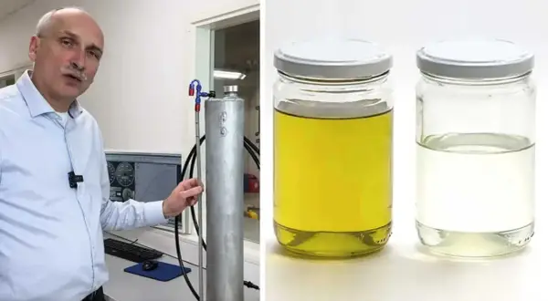 Man visar upp en tank för blankdiesel i personbil. Bredvid står två burkar med vätska, en gul och en klar.