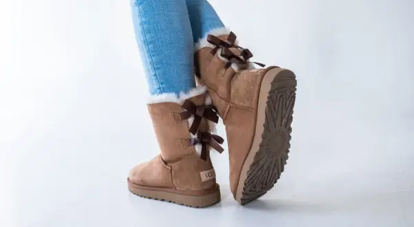 Brązowe botki UGG z kokardkami i futerkiem, idealne na zimę. Zastanawiasz się, ugg jaki rozmiar wybrać?