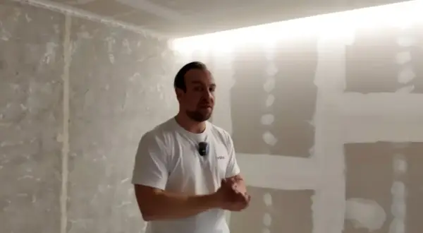 Mężczyzna prezentuje wnękę na led w suficie, która tworzy nowoczesne oświetlenie.