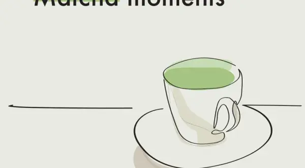 Kubek z zieloną matchą, która ma kofeinę, na talerzyku. Napis "Matcha moments".