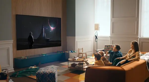 Familj tittar på en rymdfilm på TV:n, sittandes bekvämt i soffan. Avstånd tv soffa är perfekt för en mysig hemmakväll.