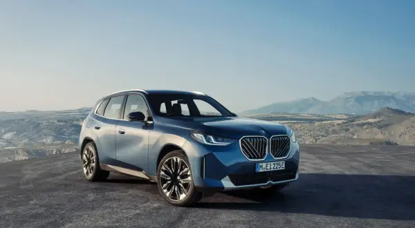 Nowy, błękitny BMW X3 2024 na tle górskiego krajobrazu.