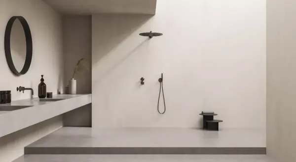 Minimalistisches Bad mit offener Dusche. Die bodentiefe Dusche ist so gestaltet, dass Spritzwasser vermieden wird. Ein runder Spiegel und ein schwebendes Waschbecken ergänzen den Look.