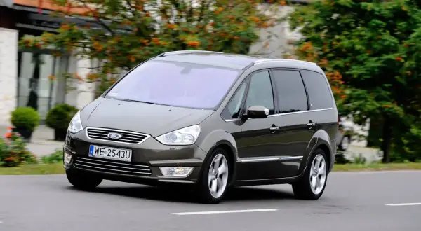 Brązowy Ford Galaxy MK2 w ruchu, z widocznymi felgami i tablicą rejestracyjną WE 2543U.