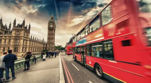 Londyn: czerwone autobusy i Big Ben na tle dramatycznego nieba.