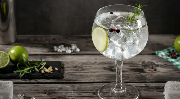 Orzeźwiający gin z tonikiem, udekorowany plasterkiem limonki, gałązką rozmarynu i ziarnami pieprzu. Idealny na letnie wieczory.