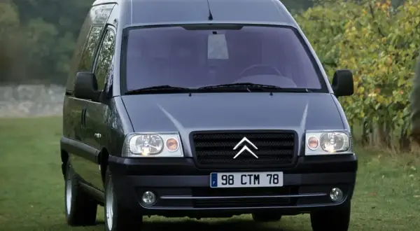 Szary Citroen Jumpy 2.0 HDI na trawie, gotowy do podróży.