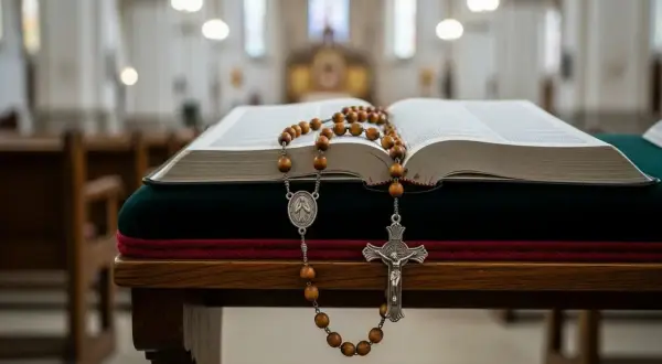 Otwarta księga i różaniec na ławce w kościele. Poniedziałkowe tajemnice różańca czekają na rozważenie.