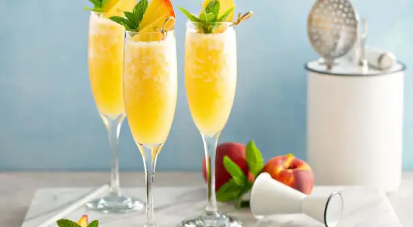 Orzeźwiający mimoza drink z brzoskwinią i miętą, idealny na letnie popołudnie.