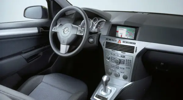 Wnętrze Opla Astry H hatchback: kierownica, deska rozdzielcza z nawigacją, dźwignia zmiany biegów i siedzenie.