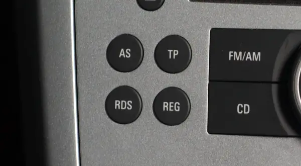 Przyciski radia samochodowego: AS, TP, RDS, REG, FM/AM, CD. RDS to system, który wyświetla dodatkowe informacje o stacji radiowej.
