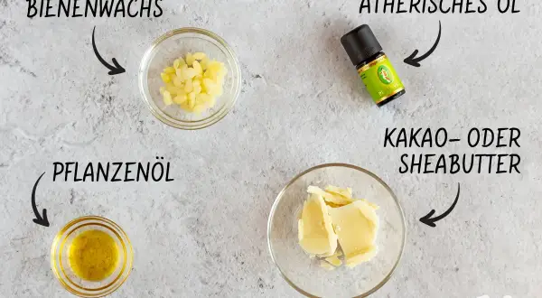 Zutaten für selbstgemachte Lotion: Bienenwachs, Pflanzenöl, Kakaobutter und ätherisches Öl.