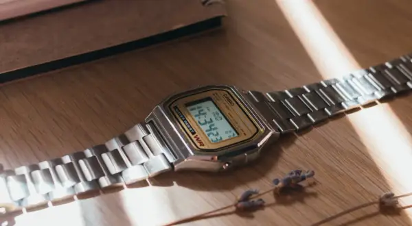 Reloj Casio plateado sobre madera. Aprende como saber si un reloj es original observando sus detalles.