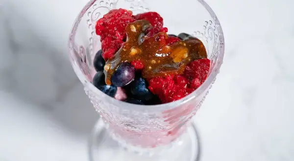 En dessertskål med bär och en karamellsås, perfekt för ett enkelt mascarpone recept.