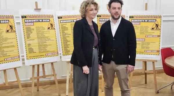 Dwie osoby stoją przed plakatami z listami ulic w Łodzi, na których planowane są remonty w 2026 roku.