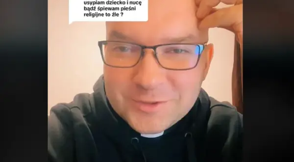 Ksiądz w okularach odpowiada na pytanie o śpiewanie pieśni religijnych podczas wykonywania domowych obowiązków lub usypiania dziecka.