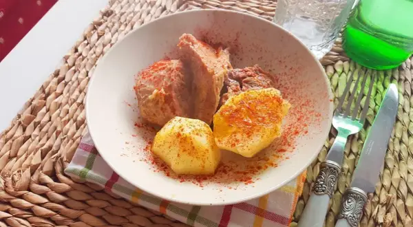 Un plato de carne o caldeiro con patatas, espolvoreado con pimentón.