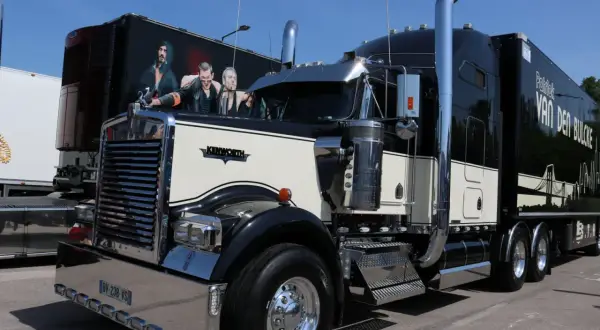 Beau camion américain Kenworth noir et crème, avec une peinture personnalisée sur la remorque.
