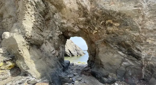 Arco natural en las calas de Villaricos, con el mar azul al fondo y rocas erosionadas.