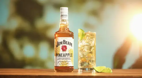 Butelka Jim Beam Pineapple i drink z limonką. Sprawdź, ile procent ma ten słodki, tropikalny likier.