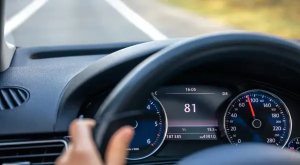 Widok na deskę rozdzielczą samochodu z włączonym tempomatem. Prędkość wynosi 81 km/h.