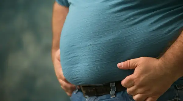 Osoba z widocznym brzuchem, potencjalnie zmagająca się z zespołem metabolicznym.