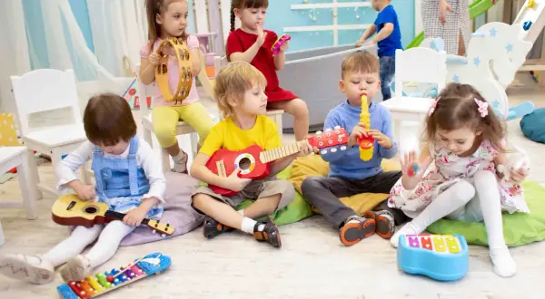 Dzieci grają na instrumentach w przedszkolu. Czy przedszkola są płatne? Ta radosna lekcja muzyki sugeruje, że warto!