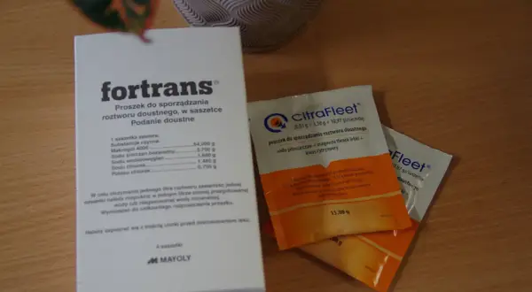 Opakowanie leku ForTrans i saszetki CitraFleet na drewnianym blacie.