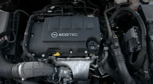 Silnik samochodowy Opel Ecotec z widocznymi przewodami i elementami.