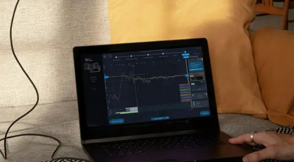 Na ekranie laptopa widoczny jest wykres kalibracji dźwięku, prawdopodobnie z użyciem systemu yamaha ypao.