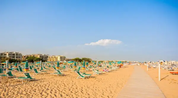 Piękna plaża w Bibione, pełna leżaków i parasoli, zaprasza do relaksu. Liczne atrakcje czekają na turystów.