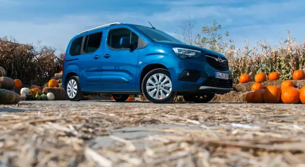 Niebieski Opel Combo Life na tle jesiennych dekoracji z dyniami i słomą. Idealny na rodzinne wycieczki.