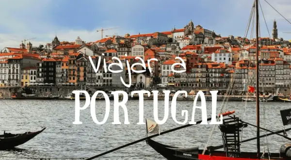 Barcos tradicionales navegan por el río Duero ante la colorida Ribeira de Oporto. ¡Descubre qué hacer en Portugal!