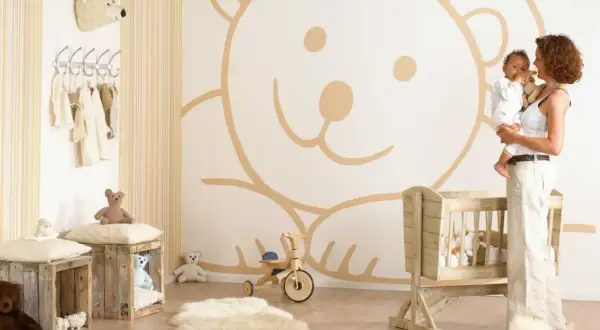 Cameretta neonato maschio con orso gigante disegnato sul muro, culla in legno e peluche. Idee pareti cameretta neonato maschio.