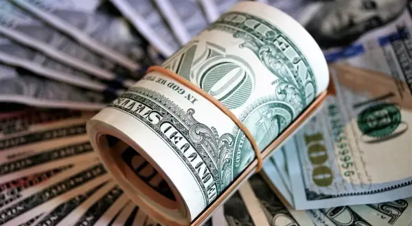 Zwinięte banknoty dolarowe, gotowe na opłacenie czynszu.